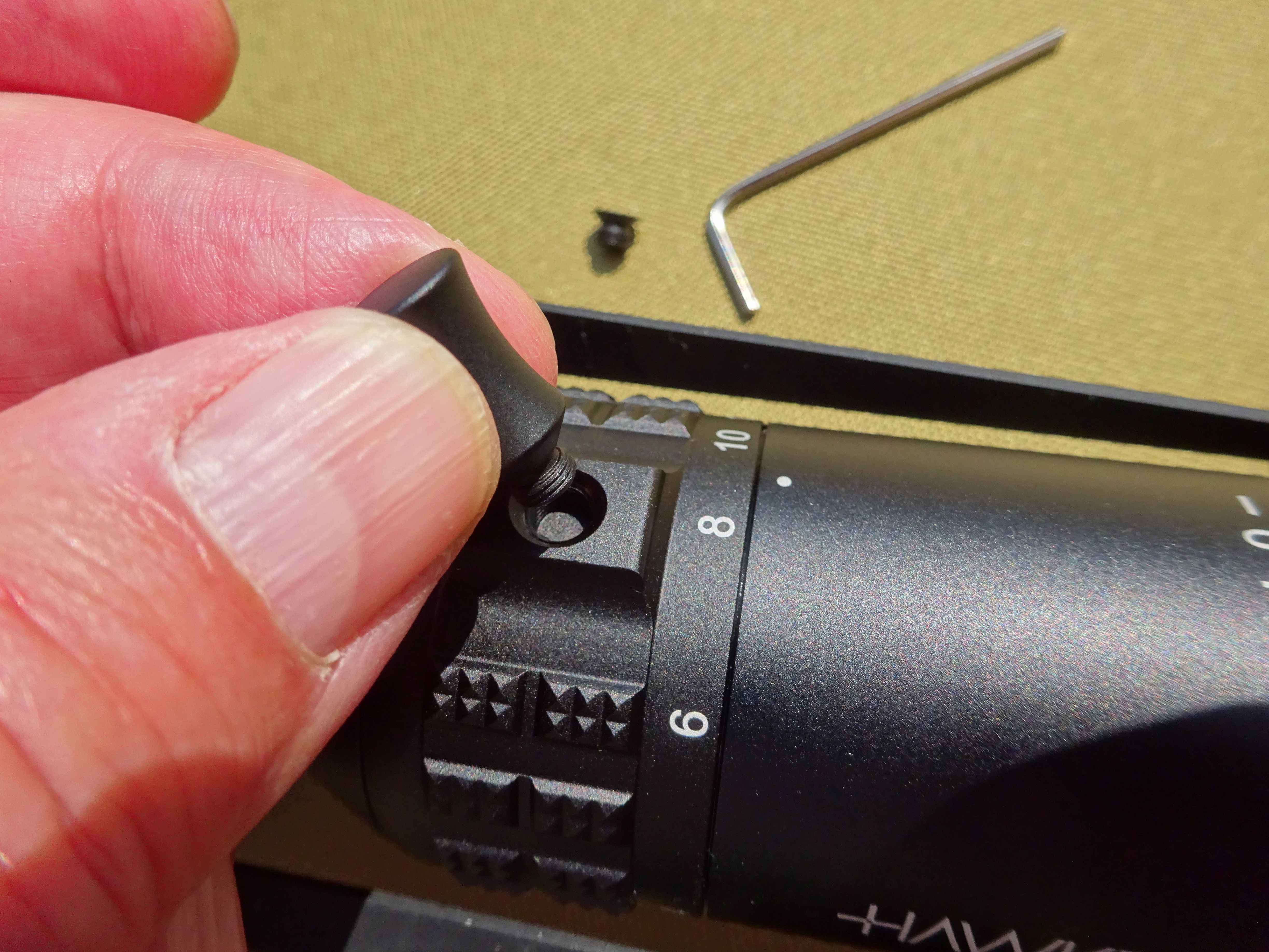 Screwing the throw lever into the magnification ring after removing the grub screw.