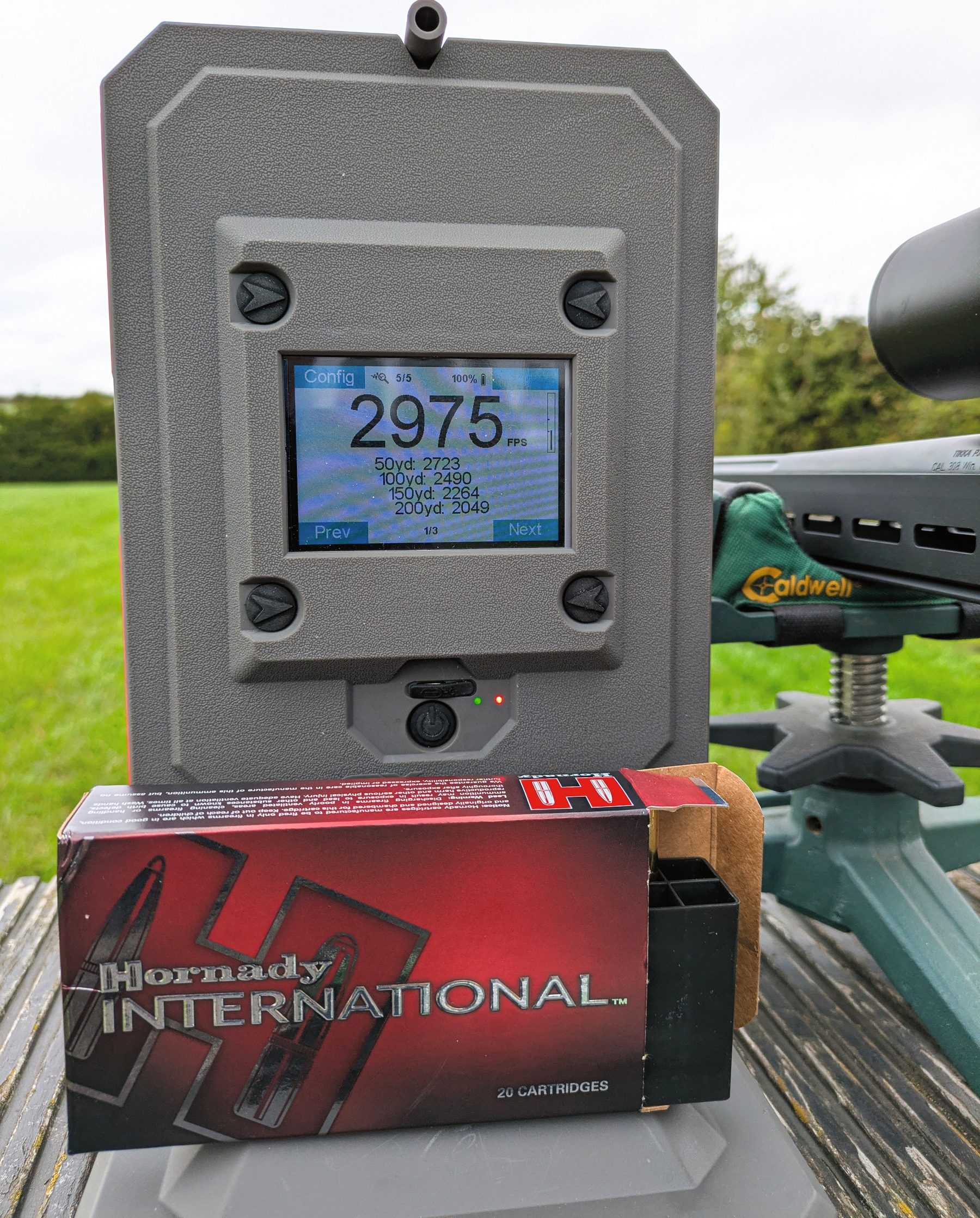 A chronograph reading 2975fps beside a box of Hornady International ECX ammunition