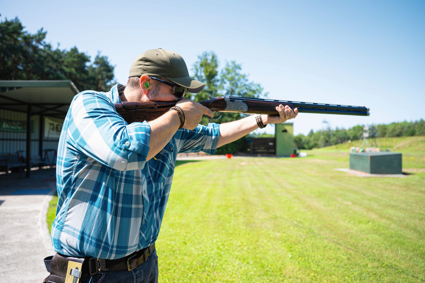 Lloyd Pattison in a checked shirt shooting the Beretta 687 500 Years LE on a clay layout