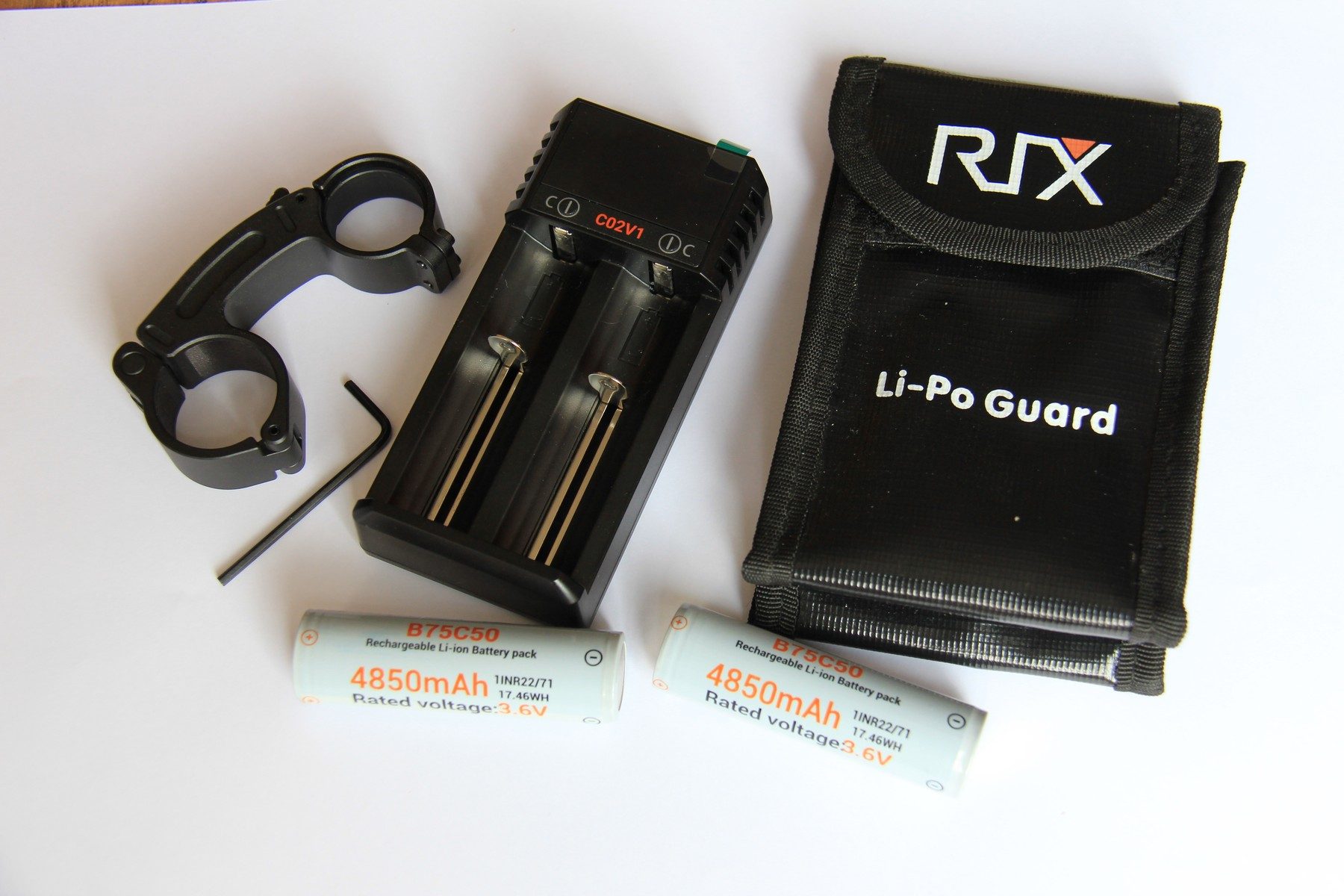 RIX Tourer T50 4K accessories laid out: IR mount, USB charger, two 21700 batteries, adaptor and battery pouch