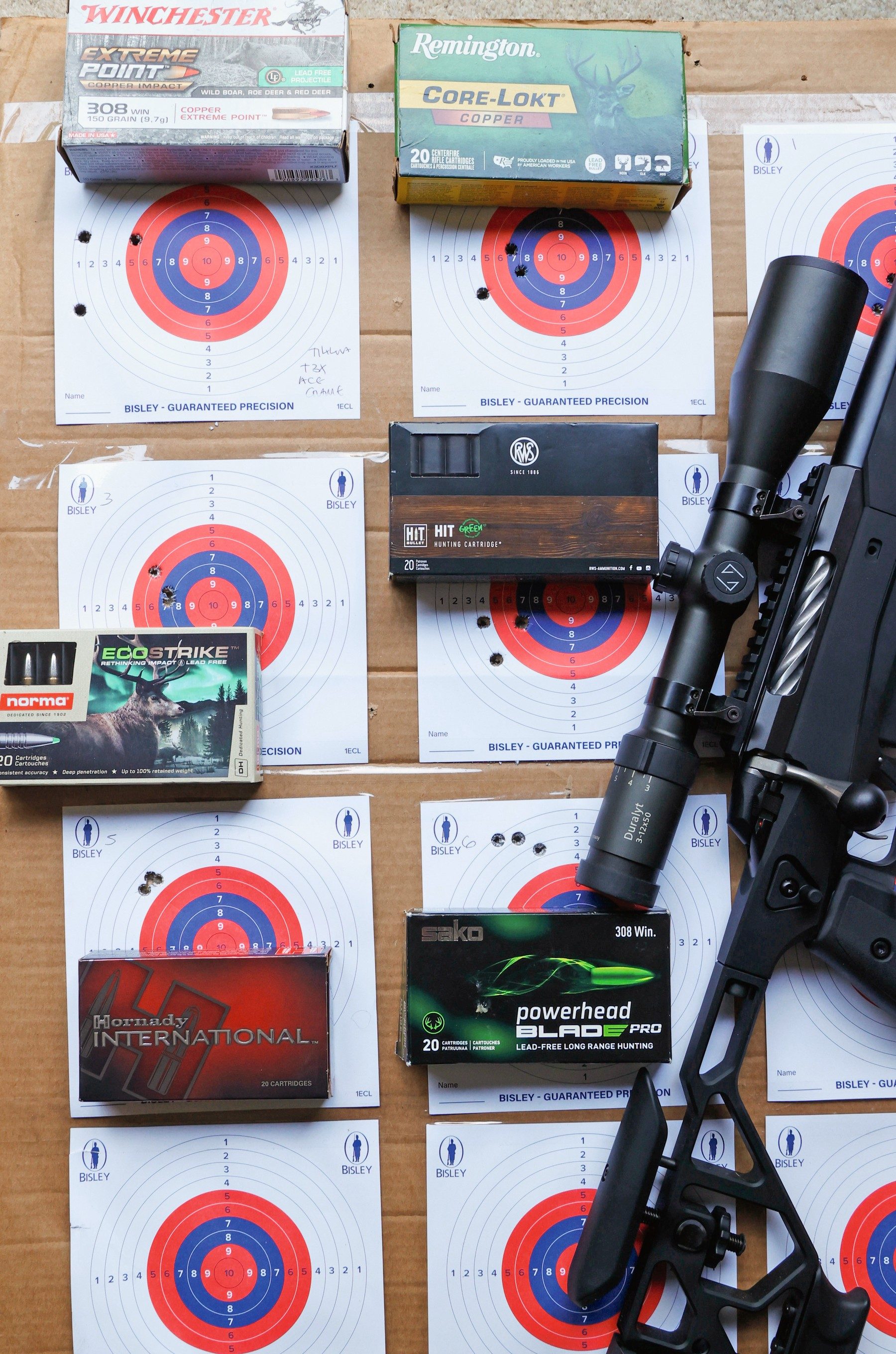 Shot targets and boxes of lead-free .308 ammunition from Hornady, Norma, Sako, Remington and RWS beside the Tikka T3x Ace Game